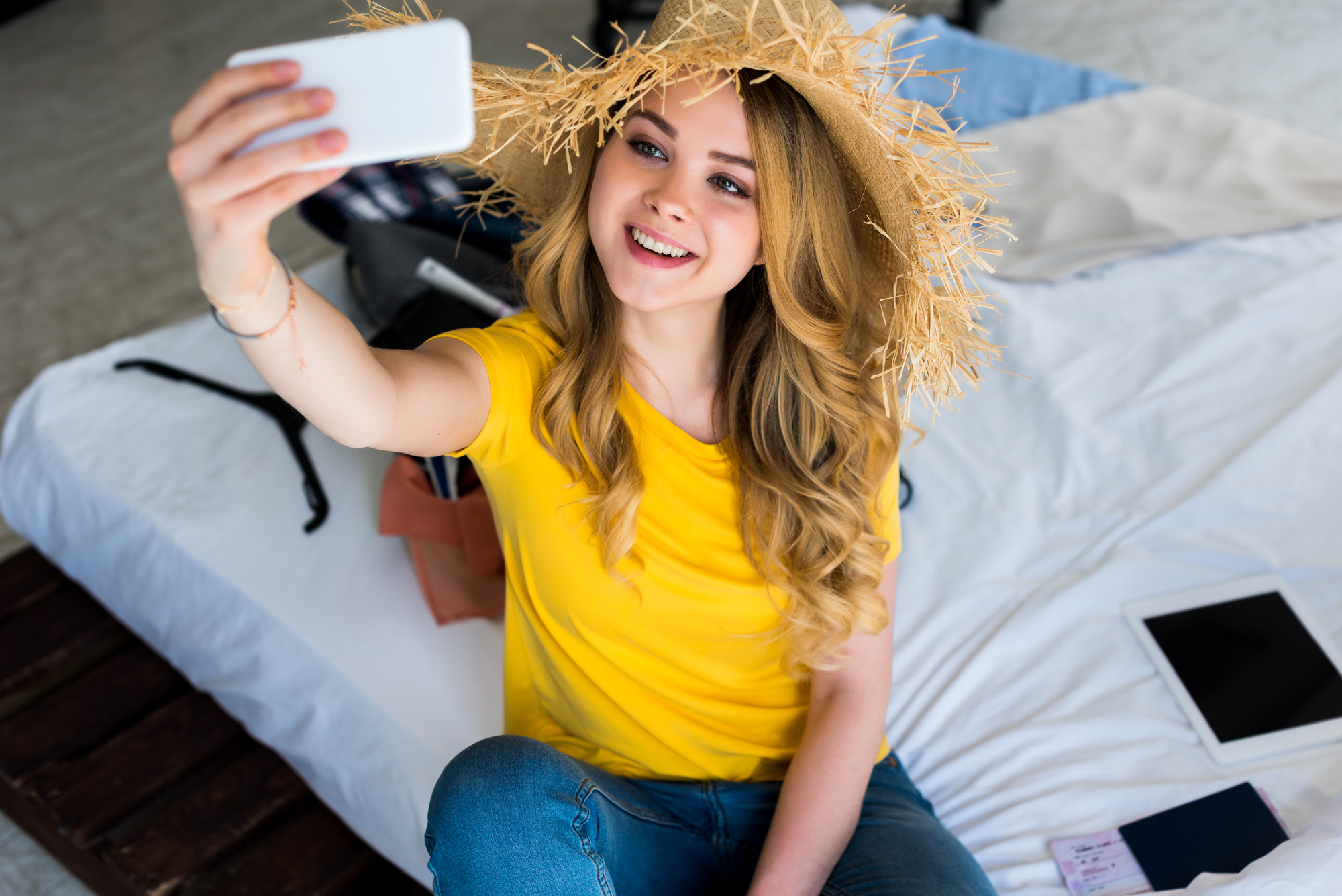 Girl taking selfie in hotel room.
